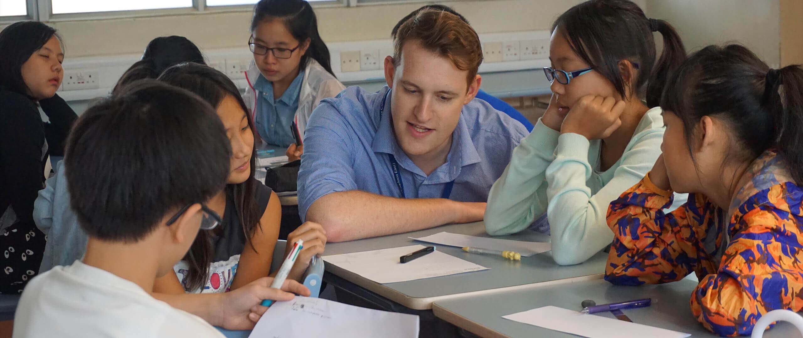 Male English teacher having a lesson with a small group of Hong Kong students.
